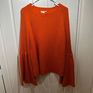 Thick, orange sweater with detailed sleeves